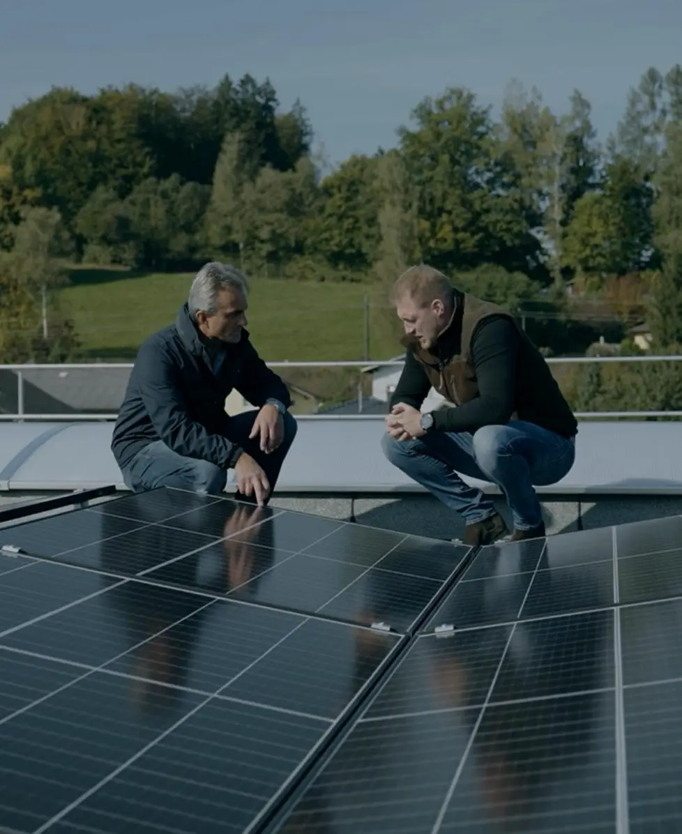 Zwei Männer unterhalten sich in der Nähe von Photovoltaikmodulen